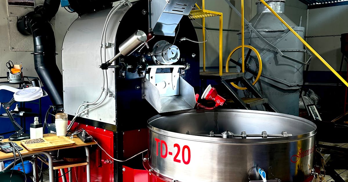 Close-up of a large industrial coffee roaster in a modern factory setting.